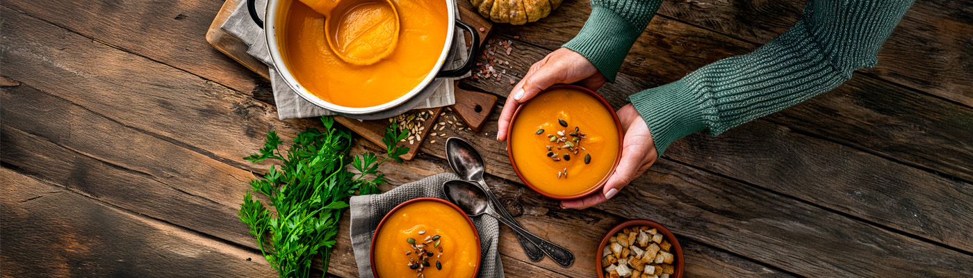 bowls of butternut squash soup on a wooden table