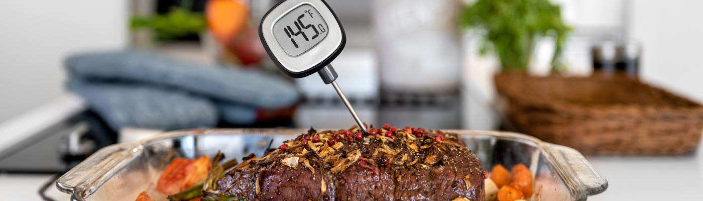 roast of beef with instant read meat thermometer inserted into the top, reads 145 degrees Celsius.